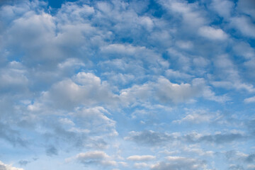 Beautiful white clouds with a pink tint on a blue sky.