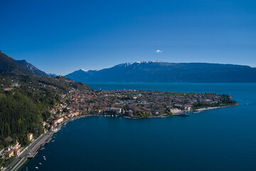 Naklejka na ściany i meble Panoramic view of the historic city of Toscolano Maderno on Lake Garda Italy. Aerial view of the town on Lake Garda. Tourist place on Lake Garda in the background Alps and blue sky.
