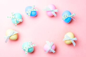 Easter background pink. Colourful egg with tape ribbon on pastel pink background in Happy Easter decoration. Flat lay, top view.