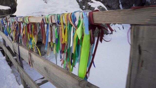 Colorful Ribbons Tied around Handrail of Wooden Bridge over Kyngarga River in Tunka Valley, Buryatia, Russia