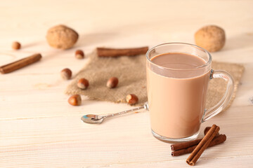 Cup of cocoa and nuts on a white wooden background with place for text