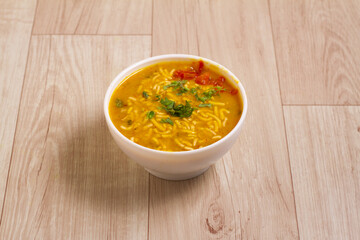 Indian Cuisine sev Kadhi - Vegetarian Curry Made of Buttermilk And Chick Pea Flour. served in a bowl or Karahi over wooden background, selective focus