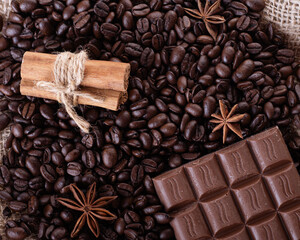 chocolate, coffee beans, anise and cinnamon on wooden background