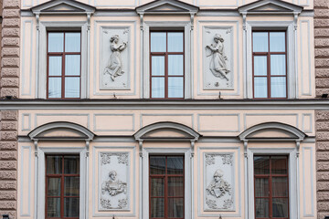 Fototapeta na wymiar Windows on old city facades, with decorative elements