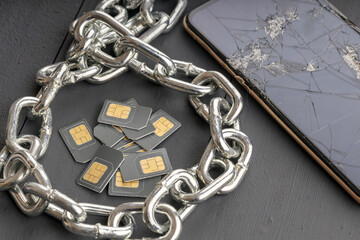 sim cards and smartphones are surrounded by a steel chain
