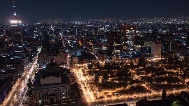 Aerial night hyperlapse orbiting Torre Latinoamericana, Bellas Artes Palace, and Alameda Central Park in Mexico City