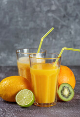 Freshly squeezed orange juice and banana and orange smoothies in tall glasses