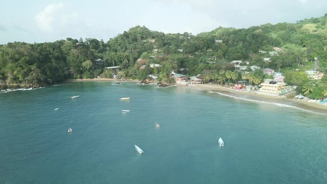Aerial view of a small fishing village with boats anchored out at sea on the tropical island of Tobago