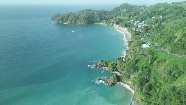 Aerial view of Castara Bay nestled on the hillside with rainforest as a backdrop, and the ocean below