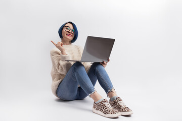 A woman sitting on the floor and holding a laptop