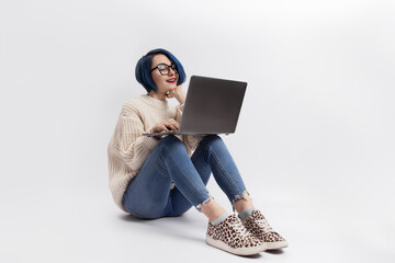 A woman sitting on the floor and holding a laptop