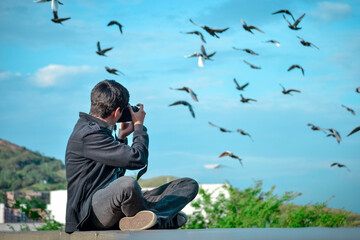 Chico fotografiando aves volando 
