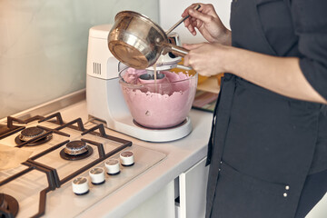 young mixed race woman is cooking a marshmallow at home