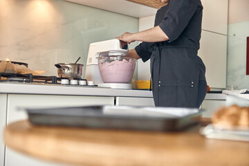 young mixed race woman is cooking a marshmallow at home