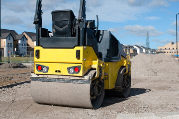 Drum Ride On Roller compacting freshly laid tarmac during roadworks and new footpath construction