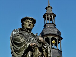 Lutherdenkmal mit Turm der Andreaskirche in Eisleben / Südharz