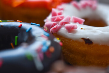 Delicious colorful donuts with different flavors and interesting decorations on the background