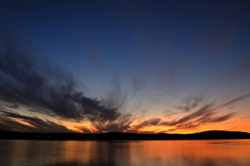 Sunset over the Kola Bay overlooking the mountains. Murmansk is located on the rocky eastern coast of the Kola Bay of the Barents Sea. The largest city in the world, located in the Arctic Circle.