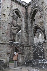 Man Wearing a Beige Coat Standing at Tintern Abbey in Monmouthshire, Wales, UK