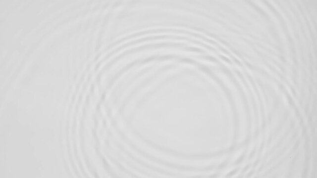 Up close, top view, Slow motion various waves of the water surface hitting the sun's rays, making them sparkle according to different patterns on a gray background video 4K.