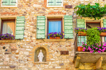 Fototapeta na wymiar Beautiful window decorated with flowers in Italy.