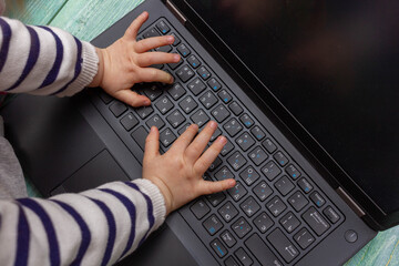 laptop notebook with child hands from above