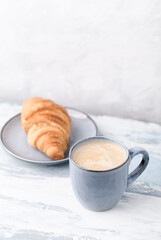 Coffee with Milk and Croissant on bright wooden background. Close up. Copy space.