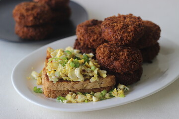 Chicken cutlets, bread and scrambled egg prepared for breakfast