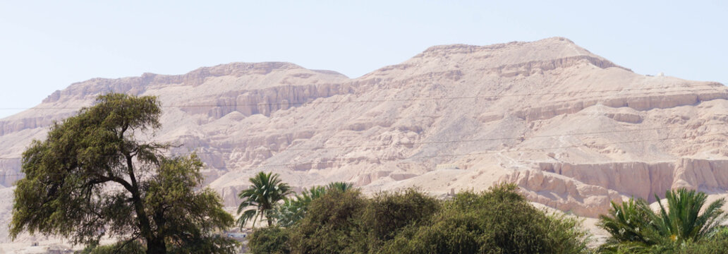 Landscape with mountains and trees in Egypt. Rocky hills. Blue sky