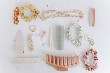 Modern summer accessories layout. Golden jewellery, hair clips, barrettes. Boho colorful accessories