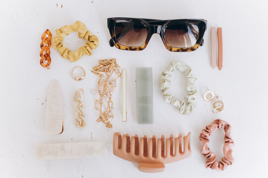 Modern summer boho accessories layout. Gold jewellery, sunglasses, hair clips, barrettes. Colorful