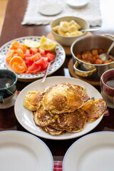 Brunch, breakfast pancakes with citrus fruits, homemade apple jam and steaming, hot cup tea or coffee. 