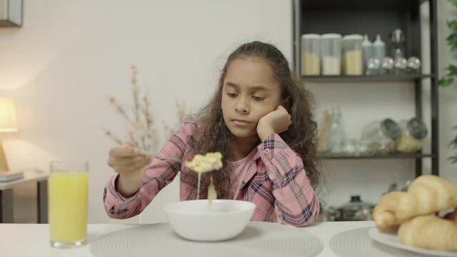 Sad biracial girl looking at dairy breakfast with disgust, lactose intolerance