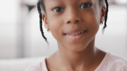 Close-up happy face mixed race black child indoor, portrait african american kind little girl daughter baby afro kid looking at camera with friendly expression blowing air kiss, love affection symbol