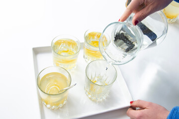 pouring a glass of charcoal filtered water into glasses. Bright light setup. 