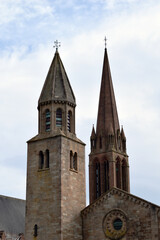 Fototapeta na wymiar Twin Stone Tower & Spire of Church seen against Cloudy Sky 