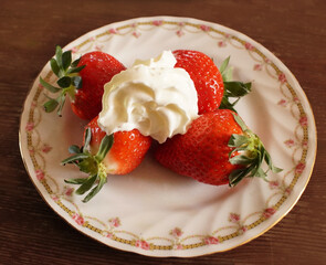 whiipped cream on big fresh strawberries in a nice plate