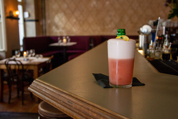 Refreshing cocktail with foam tonic, ice in bar on counter.
