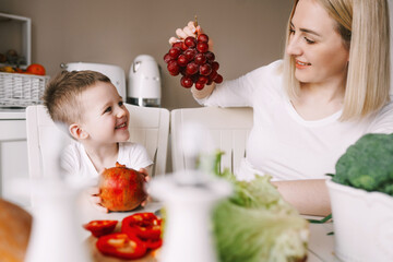 mother with little son preparing a salad of fresh vegetables