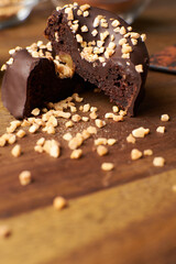 Cocoa donuts with almonds and nuts in a black and brown background vertical