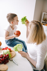 mother with little son preparing a salad of fresh vegetables