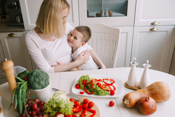 mother with little son preparing a salad of fresh vegetables