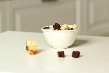 Breadcrumbs in the white plate. Breadcrumbs made from wheat flour and rye flour on the white table.