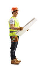 Full length profile shot of a construction worker looking at a blueprint