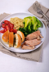 Tasty breakfast. Baked trout, salad, bulgur, homemade pie on a large white plate