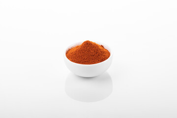 Red hot pepper powder. Pepper powder in white bowl, on white background