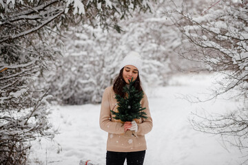Fototapeta na wymiar beautiful girl with sledges, christmas tree and gifts in winter in a snowy forest