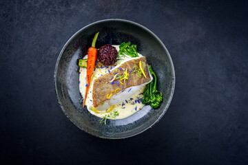 Modern style traditional fried skrei cod fish filet with baby broccoli, black red rice in lemon...