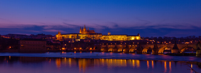 Fototapeta na wymiar Prague at night along the river with Cathedral and Castle lit up (Czech Republic)