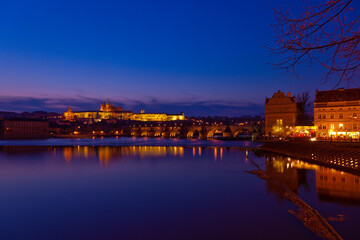 Fototapeta premium Prague at night along the river with Cathedral and Castle lit up (Czech Republic)